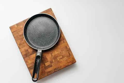 Empty pan on wood board. Empty marble coated iron pot Stock Photos