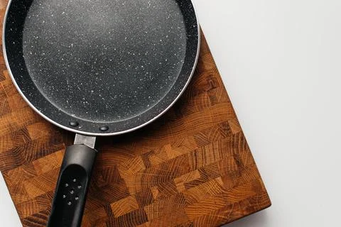 Empty pan on wood board. Empty marble coated iron pot Stock Photos
