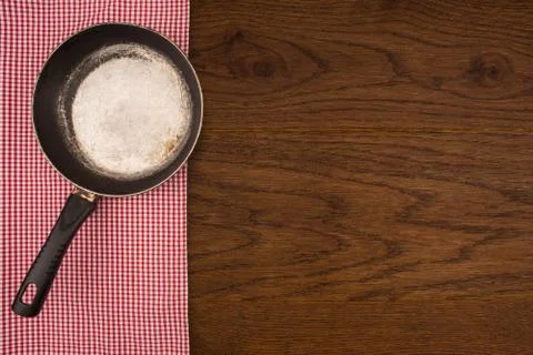 Empty pan on wooden deck table with tablecloth. Flat mock up for design. Top Stock Photos