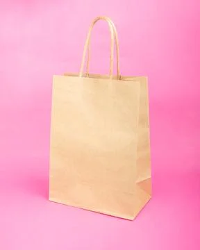 Empty paper bag with copy space for lettering, sale mockup on pink background Stock Photos