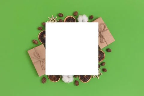 Empty paper card with frame made of natural Christmas gifts and decorations. Stock Photos