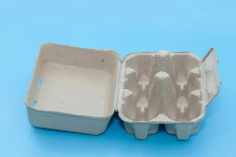 Empty paper egg tray box on blue background Stock Photos