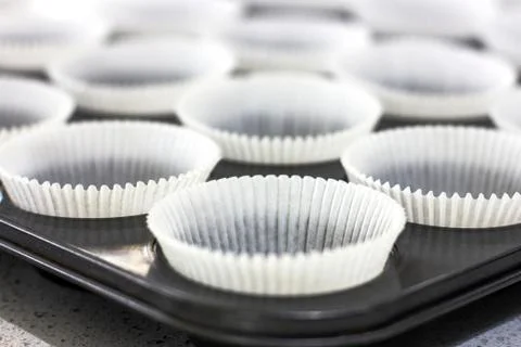 Empty paper forms for muffins and cupcakes in metal tray Stock Photos
