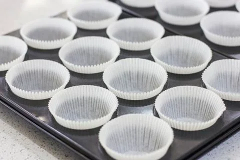 Empty paper forms for muffins and cupcakes in metal tray Stock Photos