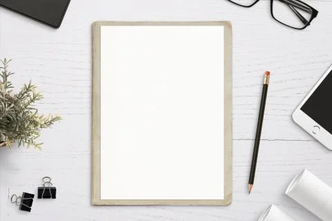 Empty paper mockup, on old folder, white wooden work desk. Top view, flat lay. Stock Photos