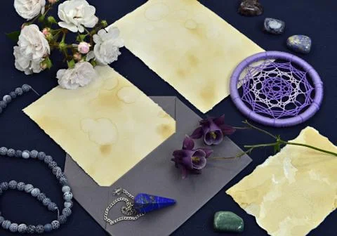 Empty paper sheets with envelope, magic objects, crystal and flower on table. Stock Photos