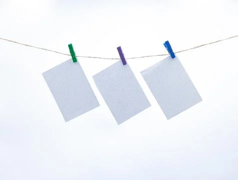 Empty paper sheets for notes, frames that hang on a rope with clothespins Stock Photos