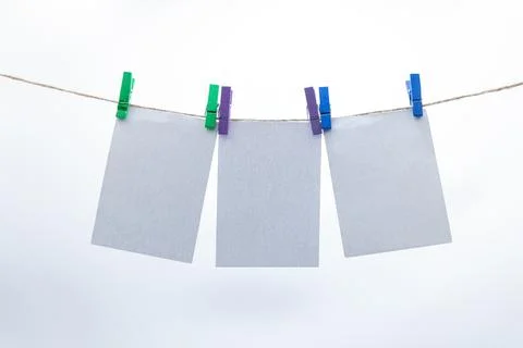 Empty paper sheets for notes, frames that hang on a rope with clothespins Stock Photos