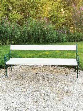 An empty park bench sitting in the grass Stock Photos