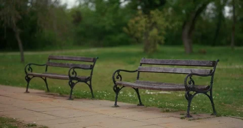 Empty park benches along paved path Stock Footage 332948655