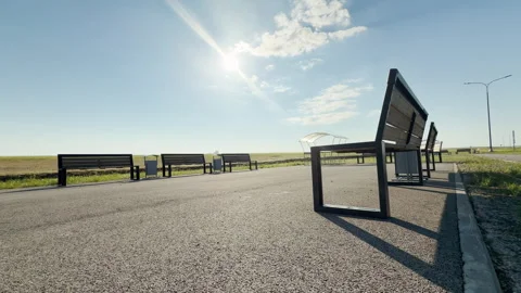 Empty Park Benches Stand Along a Paved Rest Stop Under a Bright Sun Stock Footage 335112786