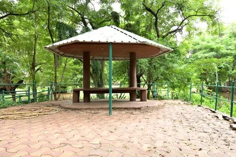 Empty park gazebo with seating surrounded by lush green trees and nature Fotos Stock