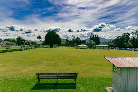 Empty Park Lawn Bench Under Dramatic Cloudy Sky Stock-Fotos