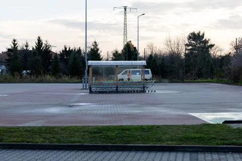 Empty parking area with bus stop and shopping carts in the morning light Stock Photos