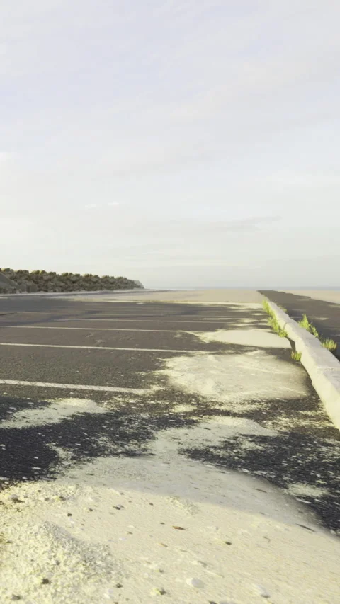 Empty parking lot by the beach with sand covering the ground and shoreline Stock-Footage 333567683
