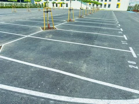 Empty parking lot during the day at a location with marked spaces and minim.. Stock Photos