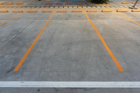 Empty parking space with orange lines on a concrete surface showing a clean.. Fotos Stock