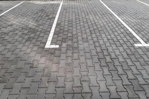 Empty parking spaces show lines on a paved surface in an outdoor location. .. Stock Photos