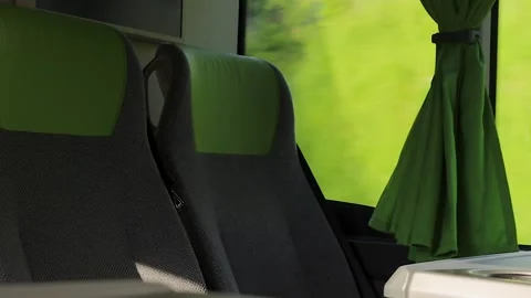 Empty passenger seats with green headrests and curtain inside a moving inte.. Stock Footage 340476885
