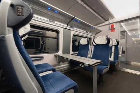 Empty passenger train carriage interior with seating area and glass door Stock Photos