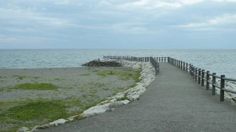 An empty path leading towards the sea Stock Photos