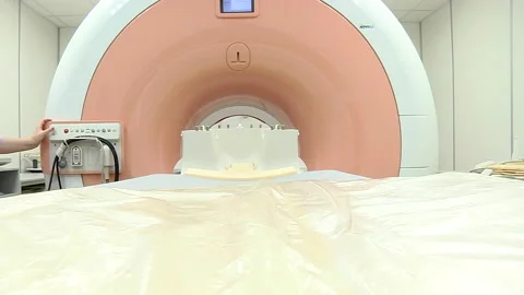 An empty patients cot moves inside a CT scanner. Video stock 160361754