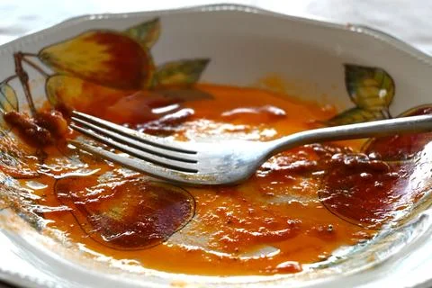 Empty patterned plate with fork and sauce remnants Stock Photos