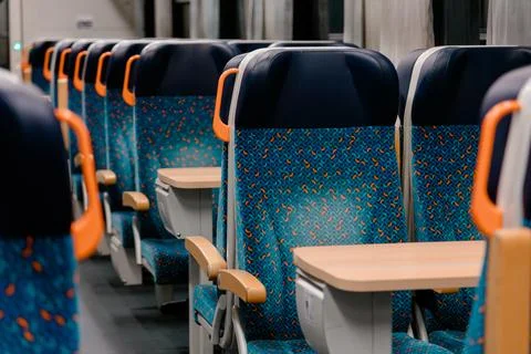 Empty patterned seats inside passenger train. Colorful patterned seats and Stock Photos