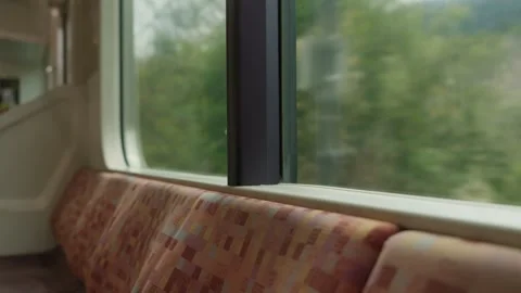 Empty patterned train seat beside window with green mountain view Japan Stock Footage 333152015