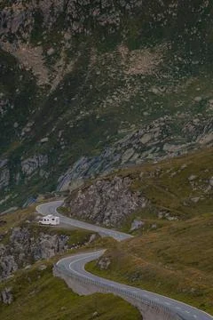 Empty paved mountain road winding through the landscape. In a small dirt Foto stock