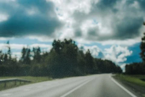 Empty paved road curving through a forested landscape beneath dramatic stor.. Stock Photos