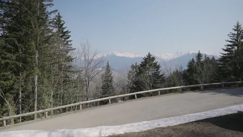 Empty paved road on mountain with view over the snowy hills and trees Stock Footage 231256580