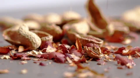 Empty peanut shells falling on gray table Video stock 331343176