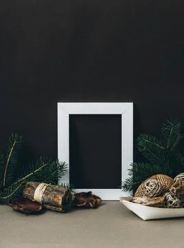 Empty photo frame on brown wall with organic christmas decoration. Styled w.. Stock Photos