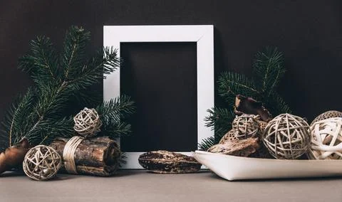 Empty photo frame on brown wall with organic christmas decoration. Styled w.. Stock Photos