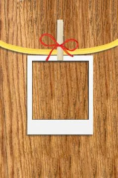 Empty photo frame with clothespin over wooden background Stock Photos