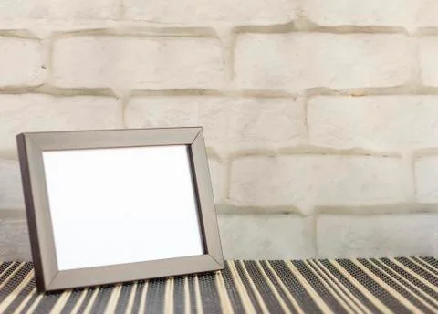 An empty photo frame in a dark frame on a table or shelf with a copy of the p Stock Photos