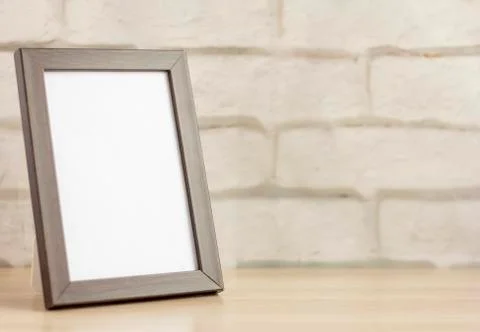 An empty photo frame in a dark frame on a table or shelf with a copy of the p Stock Photos