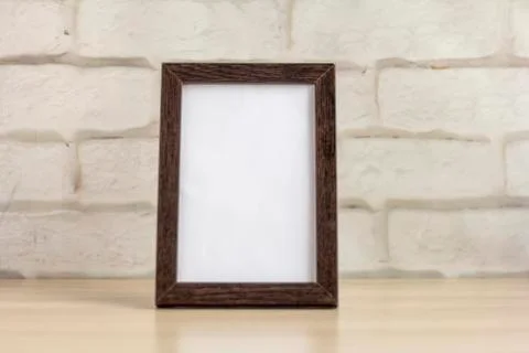 An empty photo frame in a dark frame on a table or shelf with a copy of the p Stock Photos
