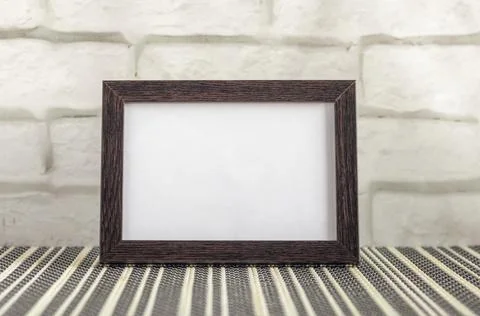 Empty photo frame in a dark frame on a table or shelf with a copy of the plac Stock Photos