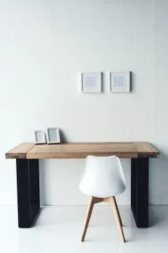 Empty photo frames hanging on wall at workplace with chair near by Foto stock