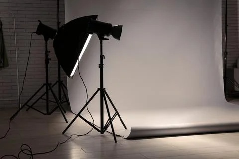 Empty photography studio with lighting equipment and backdrop 库存照片