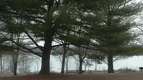 Empty Picnic Tables at Park in Winter with Lake in Background WIDE PAN Video stock 104725107