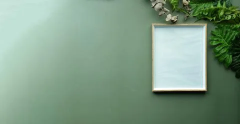 Empty picture frame and leafs on green background. Stock Photos