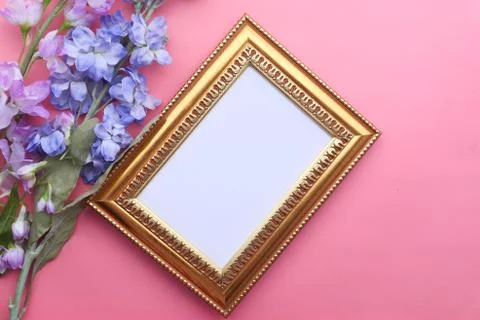 Empty picture frame with h flower on pink desk Stock Photos