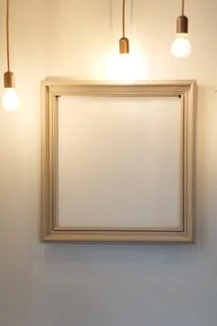An empty picture frame hanging on the wall in the warm light of paws Stock Photos