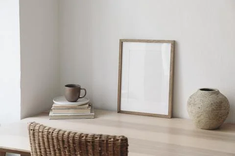 Empty picture frame mockup in boho modern minimalist interior. Wooden table 스톡 사진