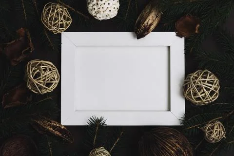 Empty picture frame with pine tree and natural christmas decoration on dark.. Stock Photos