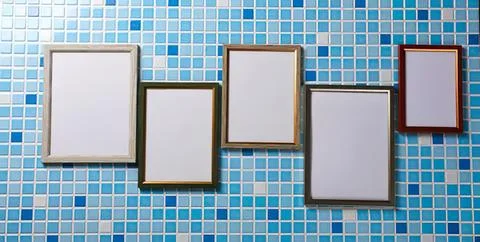 Empty picture frames hanging on a colorful tiled wall Stock Photos