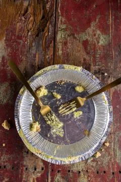 Empty pie tin with two forks on rustic wood table top view Stock Photos